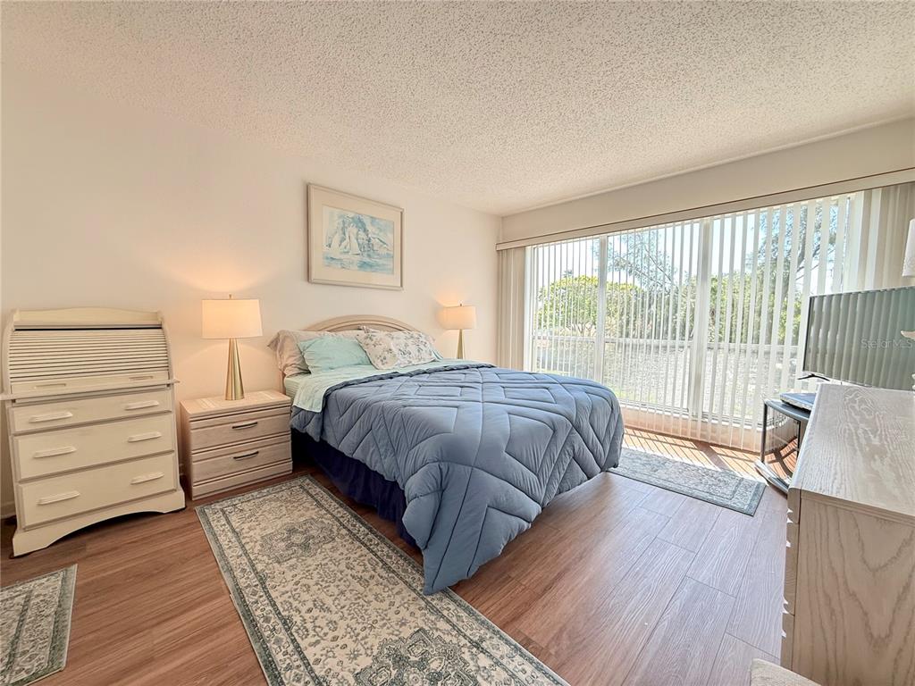 9000 Commodore Drive, Unit 302 Seminole, FL 33776 - Photo 13 of 21 a bedroom with a bed and a large window