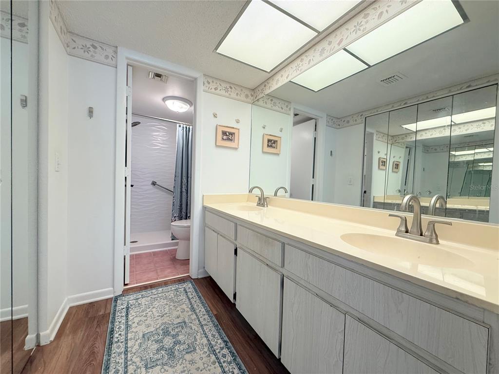 9000 Commodore Drive, Unit 302 Seminole, FL 33776 - Photo 14 of 21 a spacious bathroom with a double vanity sink mirror and toilet