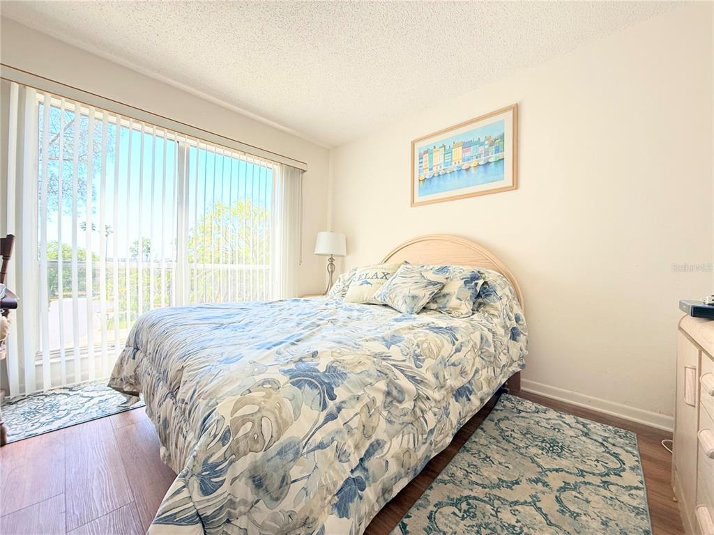 9000 Commodore Drive, Unit 302 Seminole, FL 33776 - Photo 16 of 21 a bedroom with a bed and a painting on the wall