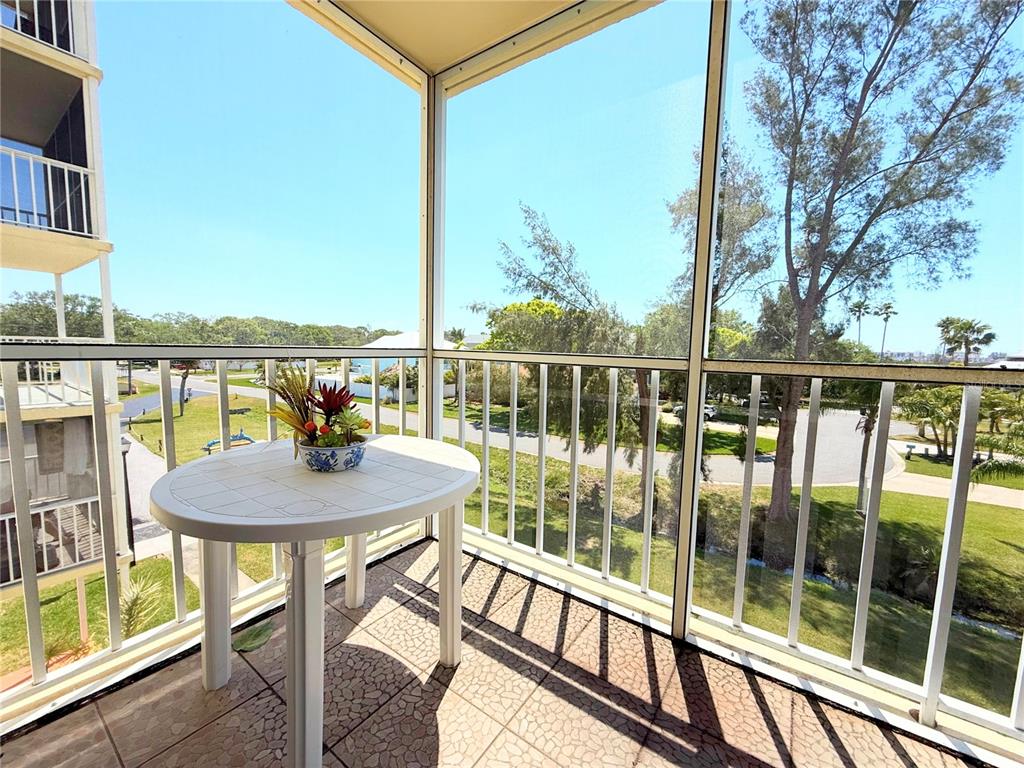 9000 Commodore Drive, Unit 302 Seminole, FL 33776 - Photo 18 of 21 a view of a balcony with a table and chairs