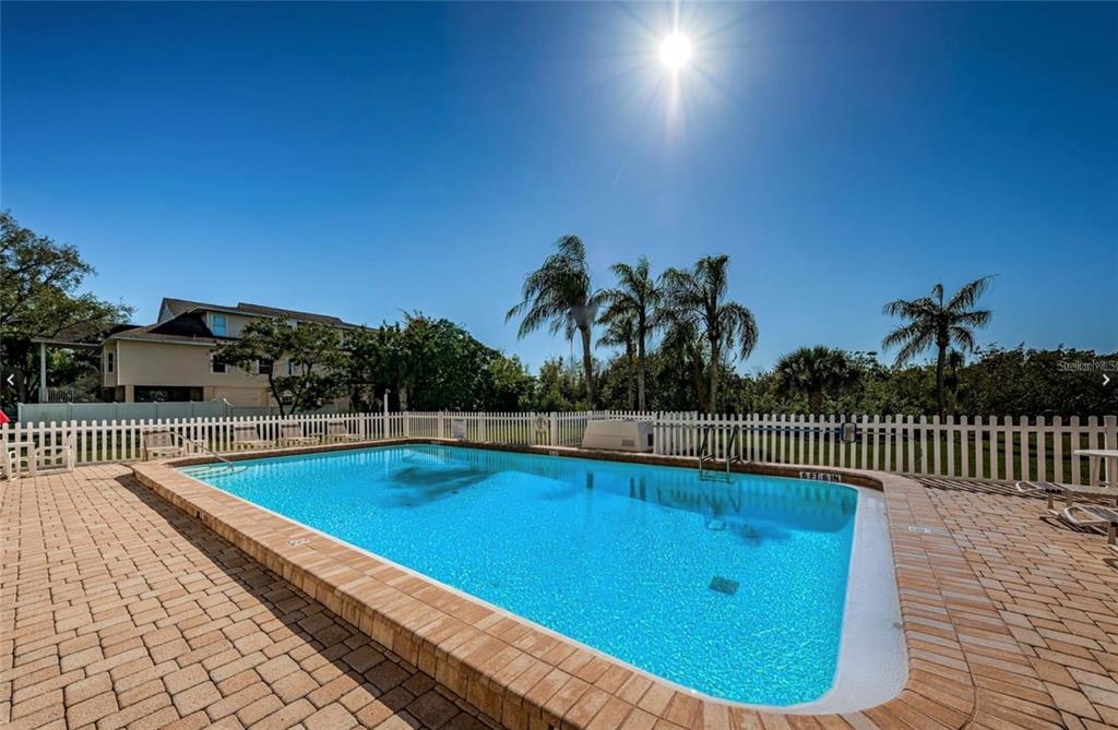 9000 Commodore Drive, Unit 302 Seminole, FL 33776 - Photo 5 of 21 a view of a swimming pool with seating space