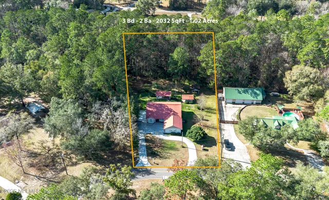 an aerial view of residential houses with outdoor space and trees