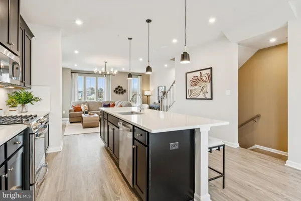 a kitchen with kitchen island a sink stove and wooden floor