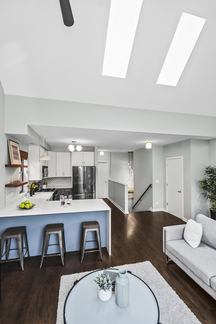 2035 West Crystal Street, Unit 3 Chicago, IL 60622 - Photo 7 of 18 a kitchen with stainless steel appliances kitchen island granite countertop a dining table chairs and a refrigerator