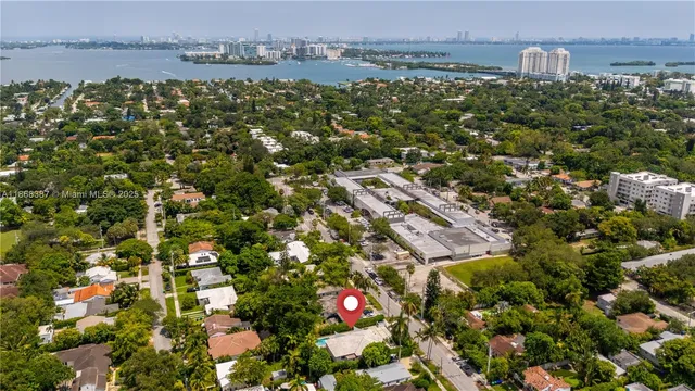 an aerial view of residential houses with outdoor space and trees