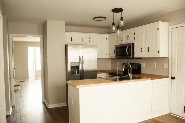 a kitchen with stainless steel appliances a refrigerator sink and cabinets