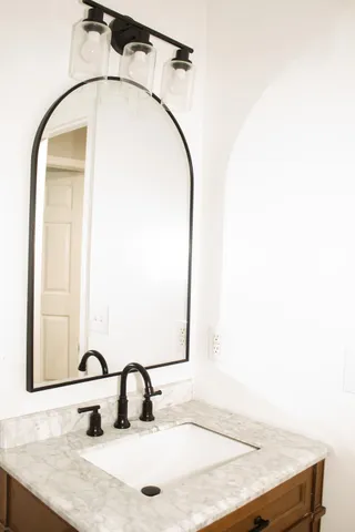 a bathroom with a sink vanity and a mirror