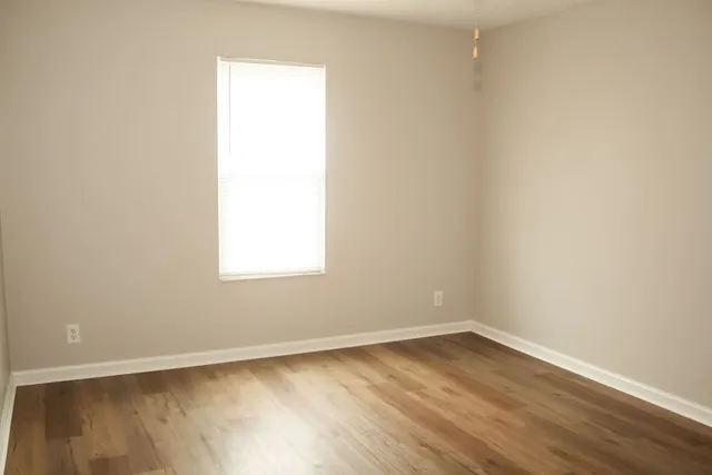 a view of a small space with wooden floor and a window