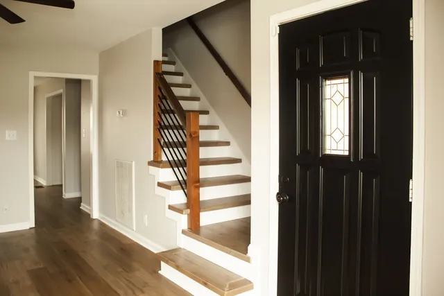 a view of a hallway with wooden floor and entryway