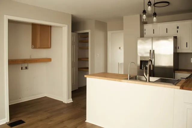 a view of a kitchen with a sink and a refrigerator