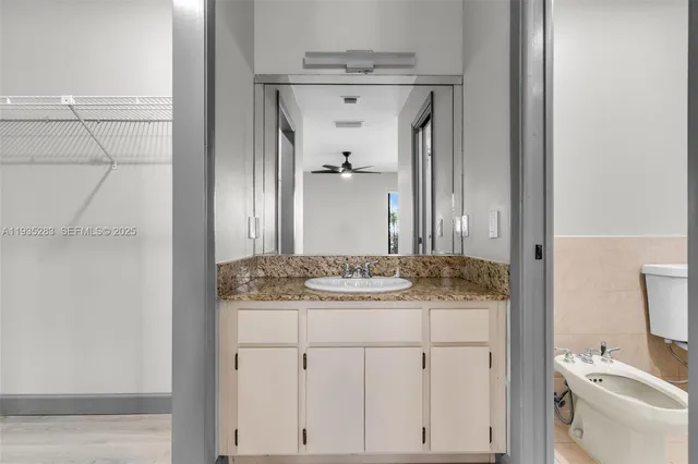 a bathroom with a granite countertop sink and a mirror