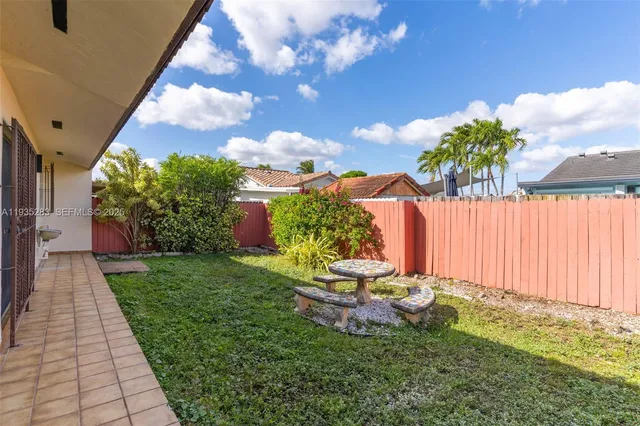 a backyard of a house with table and chairs