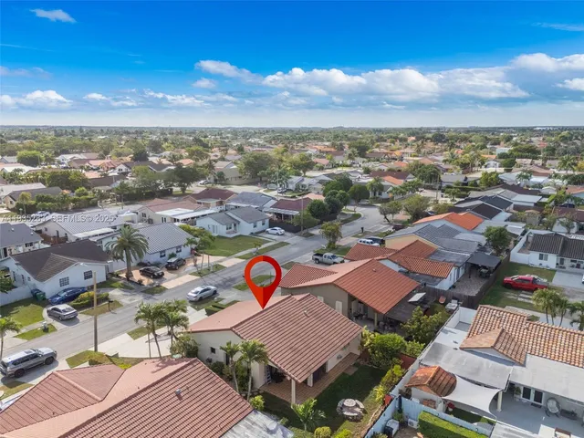 an aerial view of a city with lots of residential buildings ocean and mountain view in back