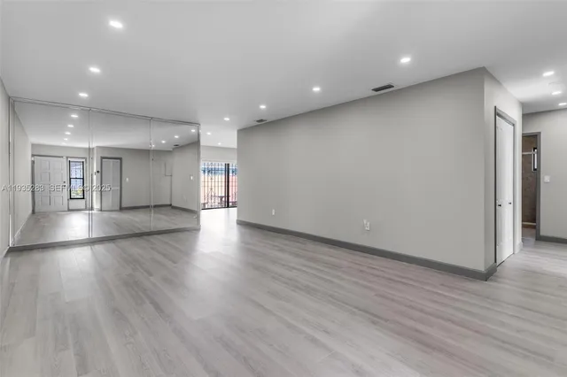 a view of an empty room with wooden floor