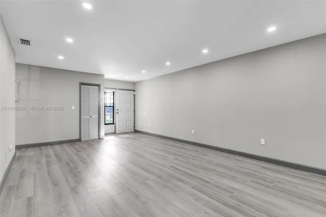 a view of an empty room with wooden floor