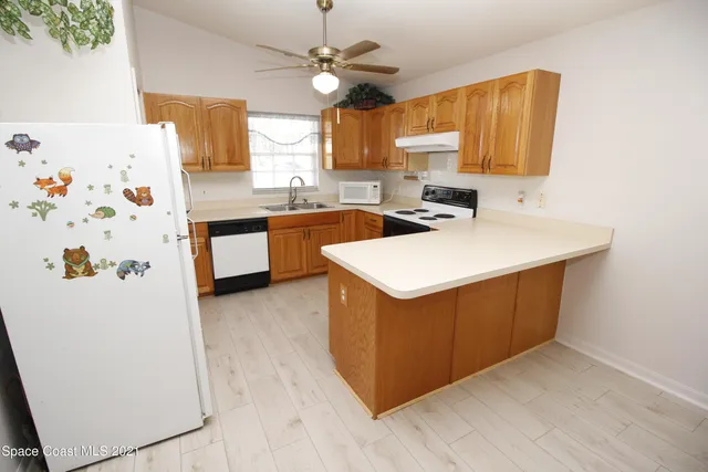 a kitchen with stainless steel appliances a stove a sink a refrigerator a center island and cabinets