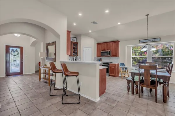 a open kitchen with stainless steel appliances kitchen island granite countertop a table and chairs in it