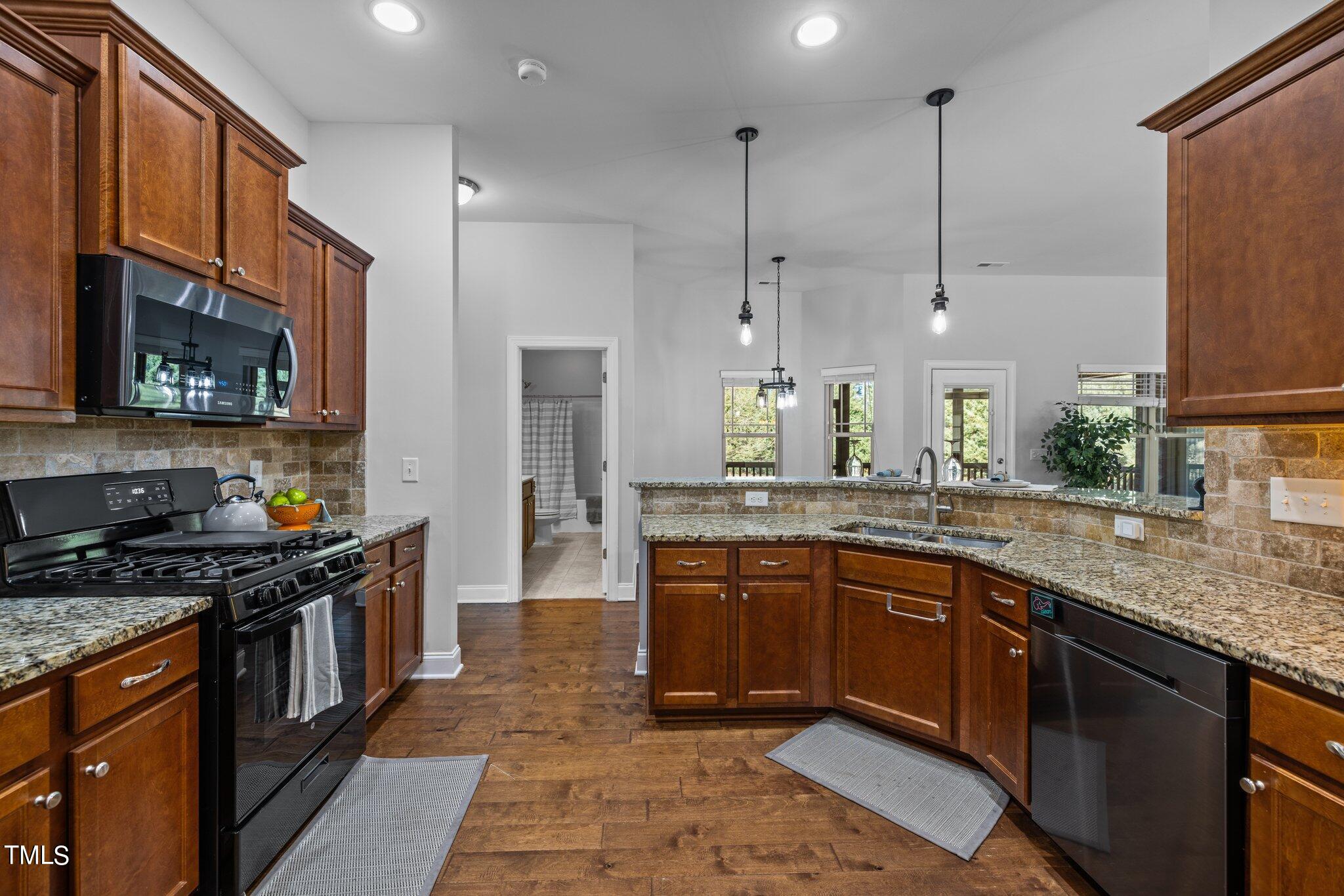 95 Windy Creek Drive Willow Spring, NC 27592 - Photo 13 of 55 a kitchen with stainless steel appliances granite countertop a sink a stove a refrigerator cabinets and a wooden floor