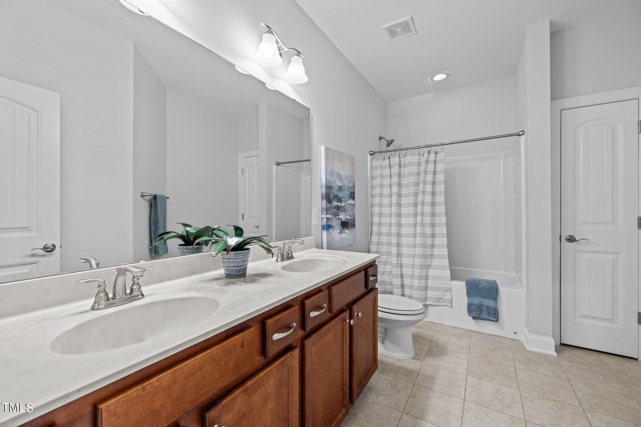 95 Windy Creek Drive Willow Spring, NC 27592 - Photo 25 of 55 a bathroom with a double vanity sink toilet and shower