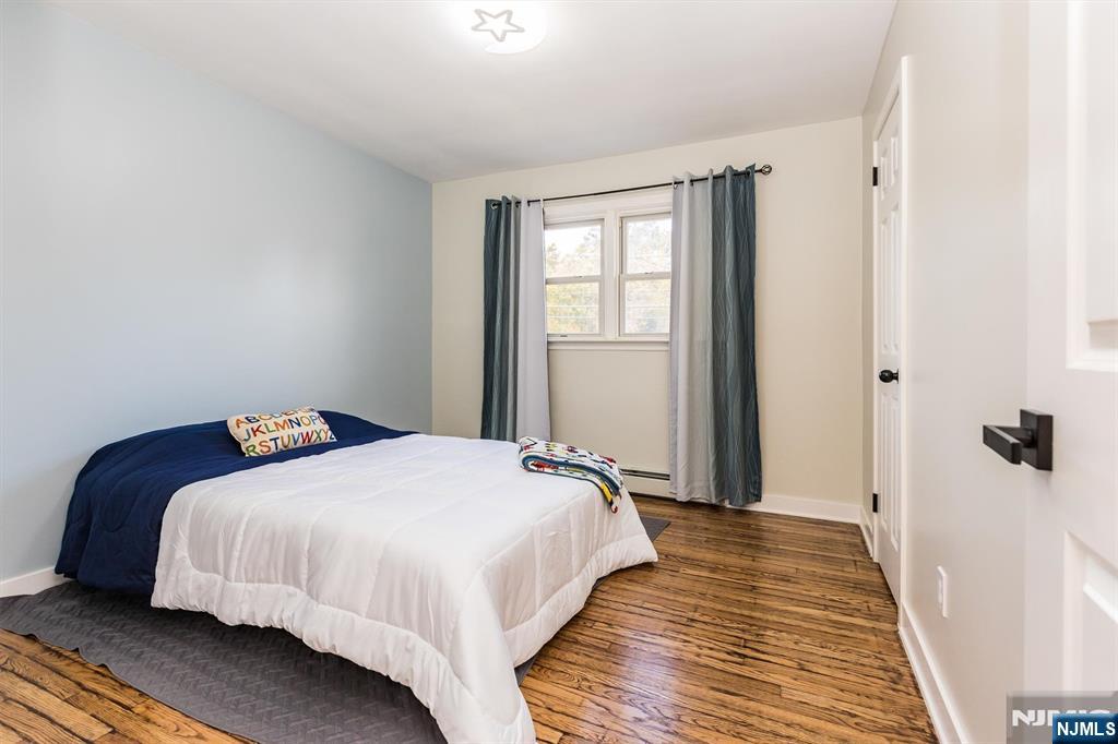 179 Grove Avenue Verona, NJ 07044 - Photo 24 of 34 a bedroom with a bed and wooden floor