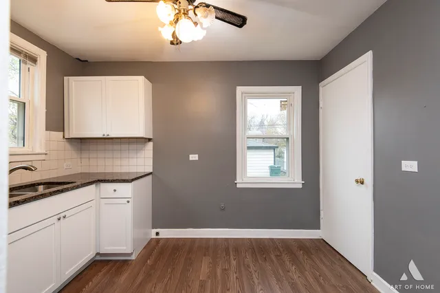 a view of a kitchen with wooden floor and a window