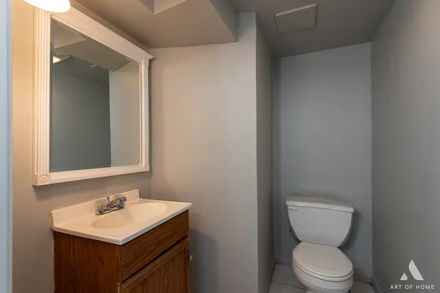 a bathroom with a toilet sink and mirror