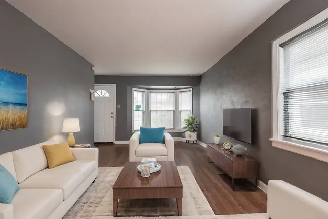 a living room with furniture a large window and a flat screen tv