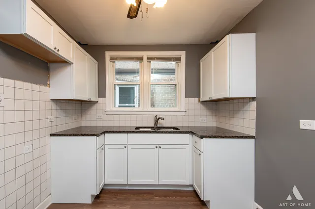 a kitchen with white cabinets appliances and a sink