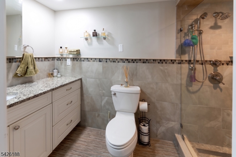 4 Millay Court Teaneck, NJ 07666 - Photo 7 of 32 a bathroom with a granite countertop toilet and a sink