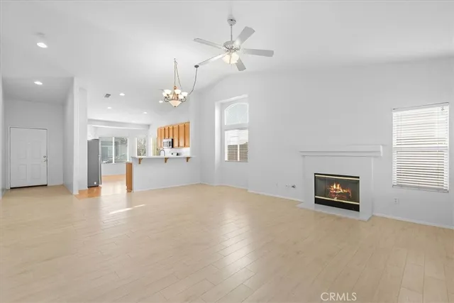 an empty room with windows and fireplace