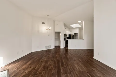 a view of a kitchen with wooden floor and a refrigerator