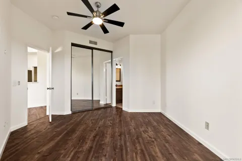 a bathroom with a granite countertop toilet a sink and mirror
