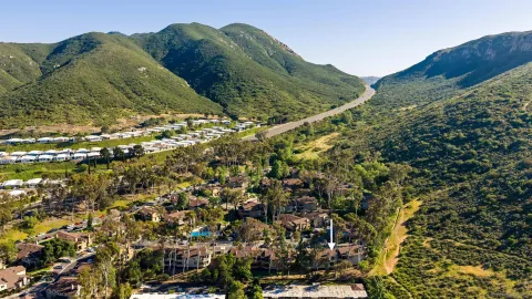 an aerial view of ocean and residential houses with outdoor space