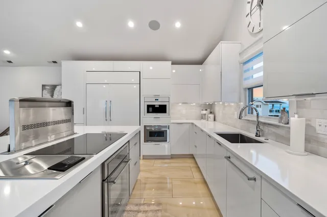 a kitchen with stainless steel appliances granite countertop a sink and a stove
