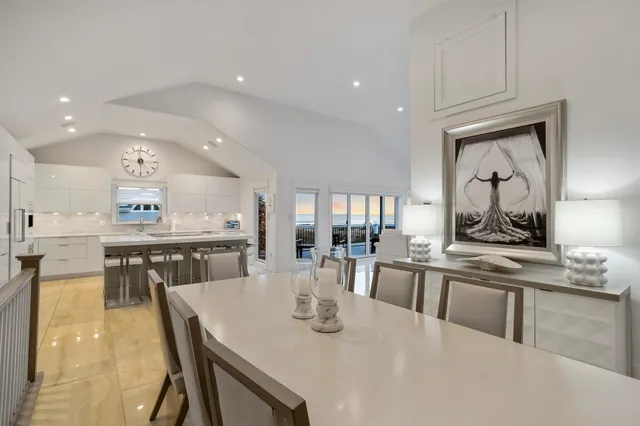 a kitchen with stainless steel appliances granite countertop a stove a sink a dining table and chairs