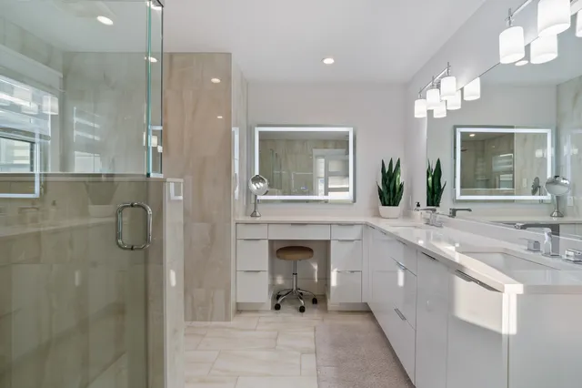 a bathroom with a double vanity sink mirror and shower