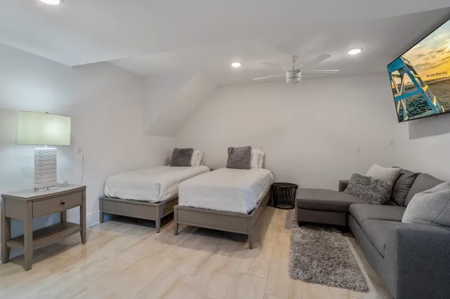 a spacious bedroom with a bed a couch and a lamp on table