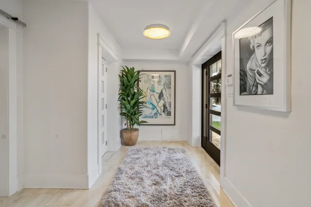 a view of a hallway with furniture and window