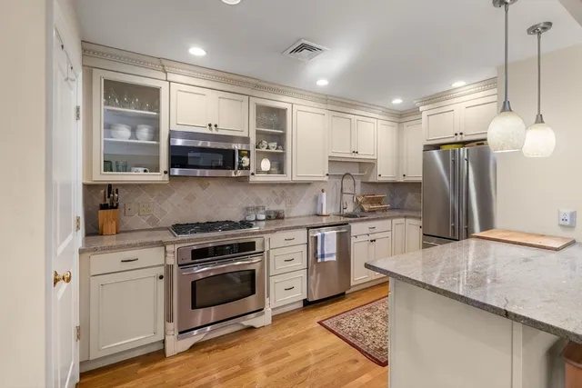 a kitchen with refrigerator cabinets and wooden floor