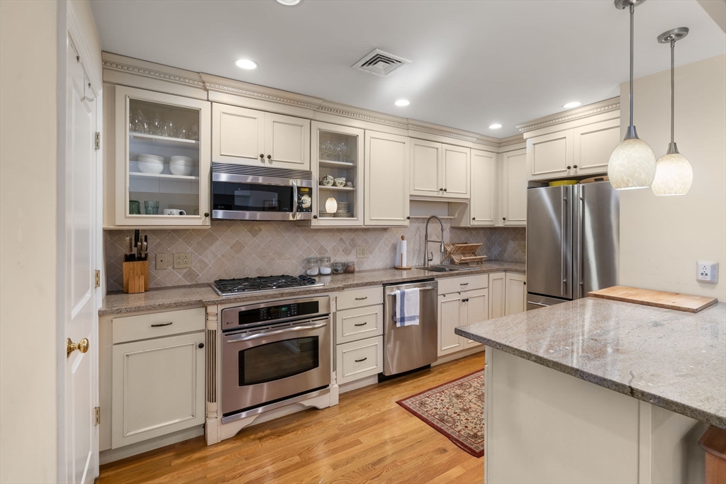 299 Marlborough Street, Unit 1 Boston, MA 02116 - Photo 3 of 15 a kitchen with refrigerator cabinets and wooden floor
