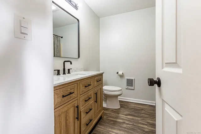 a bathroom with a toilet sink and mirror