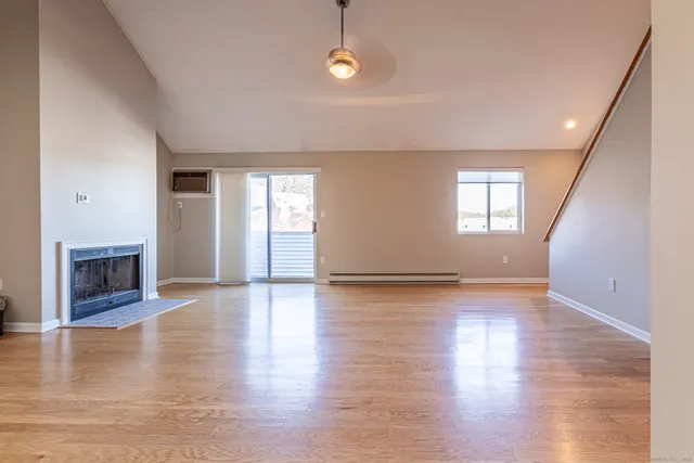 an empty room with wooden floor and fireplace
