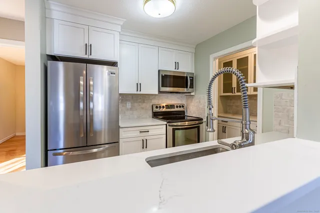 a kitchen with granite countertop a refrigerator and a sink