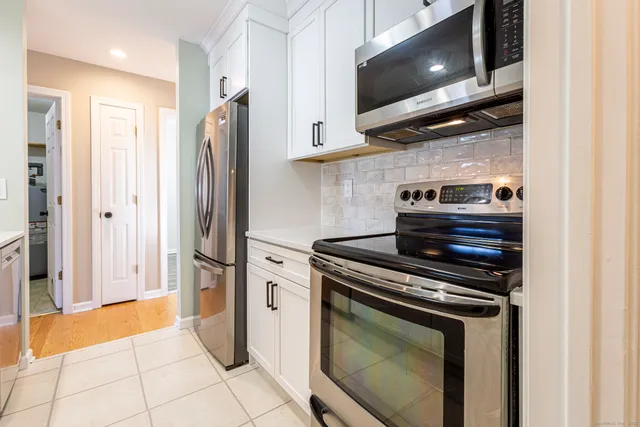 a kitchen with stainless steel appliances granite countertop a refrigerator and a stove top oven