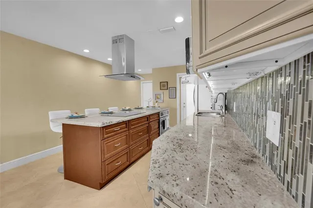 a kitchen with stainless steel appliances granite countertop a sink a stove and a refrigerator