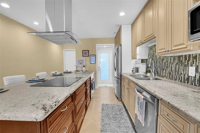 a kitchen with granite countertop a sink a counter top space and stainless steel appliances