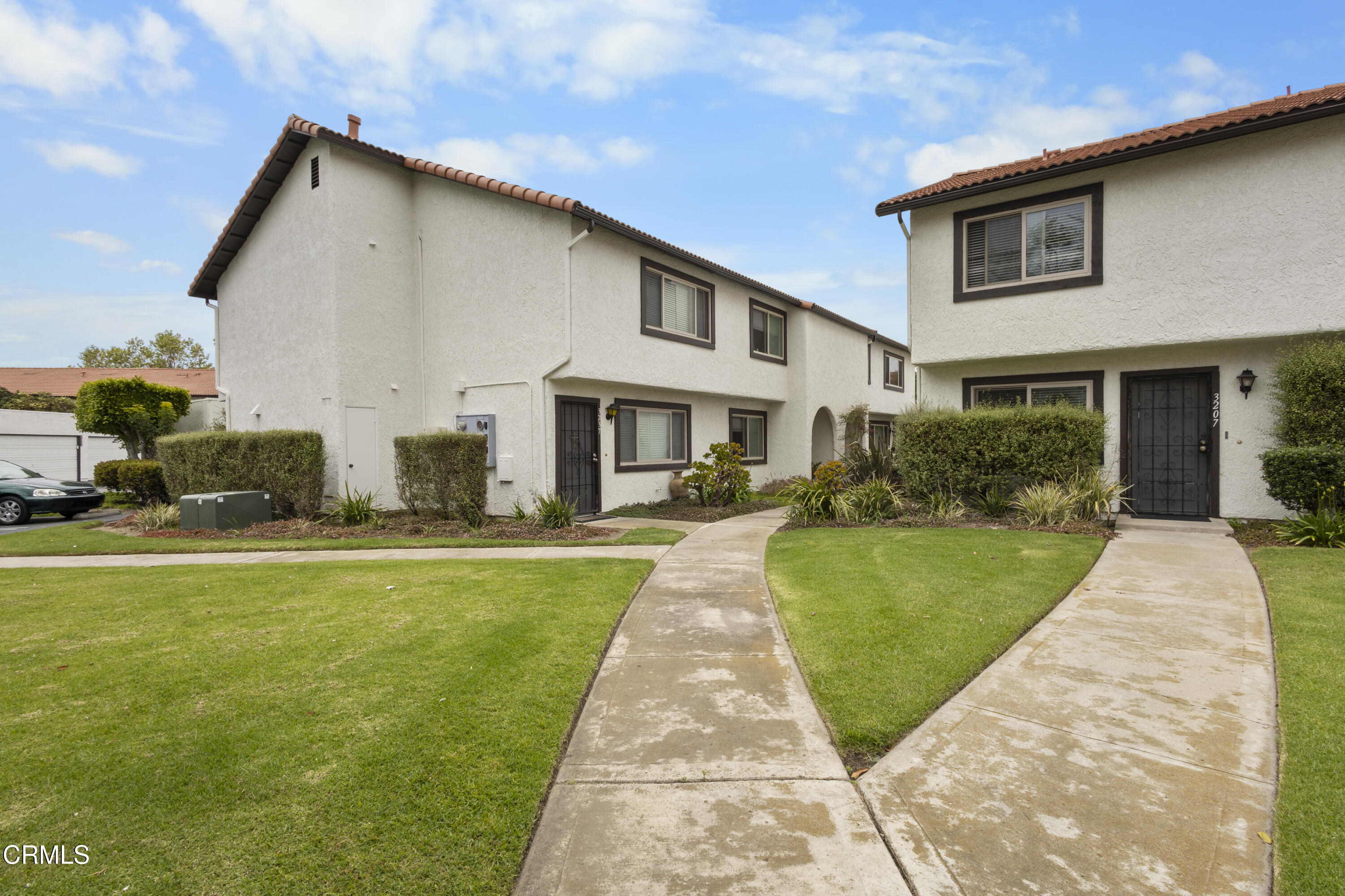 a front view of a house with a yard and potted plants
