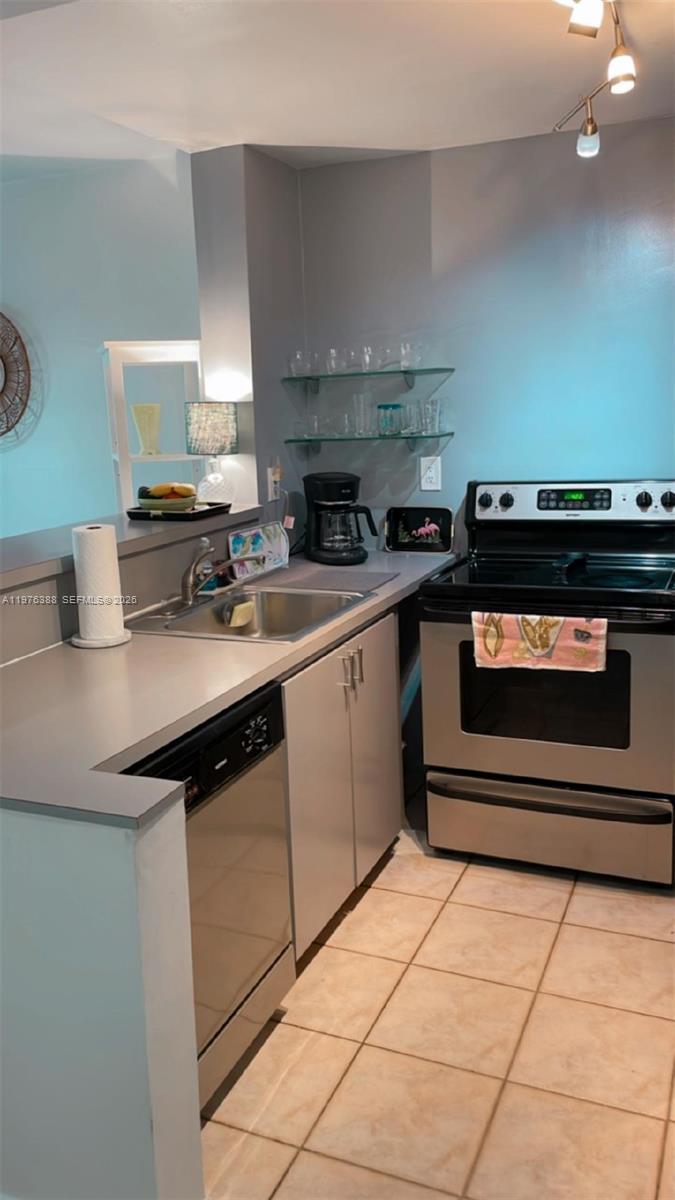 1673 Bay Road, Unit 303 Miami Beach, FL 33139 - Photo 3 of 10 a kitchen with a sink stove and cabinets
