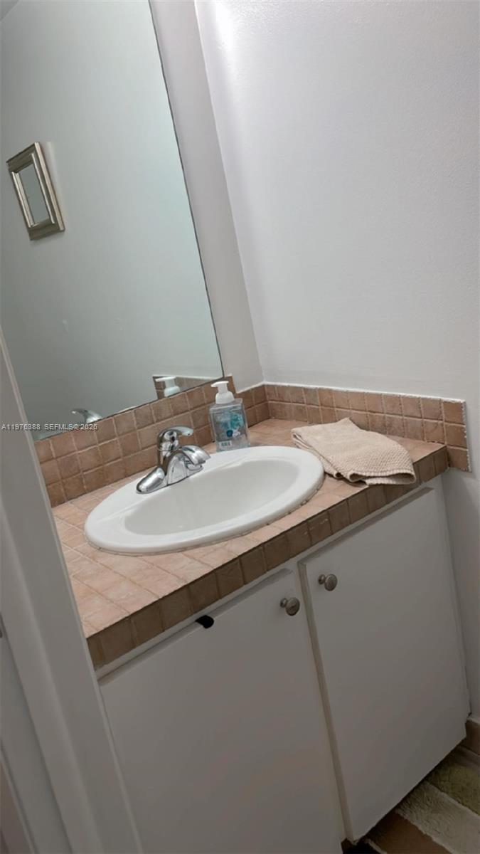 1673 Bay Road, Unit 303 Miami Beach, FL 33139 - Photo 4 of 10 a bathroom with a sink and a mirror