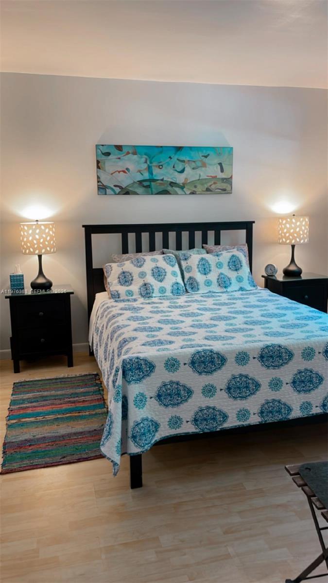 1673 Bay Road, Unit 303 Miami Beach, FL 33139 - Photo 5 of 10 a bedroom with a bed and a night stand